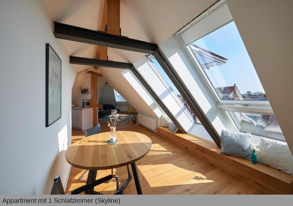 una stanza con un tavolo e alcune ampie finestre di Lofts in Hannover ad Hannover
