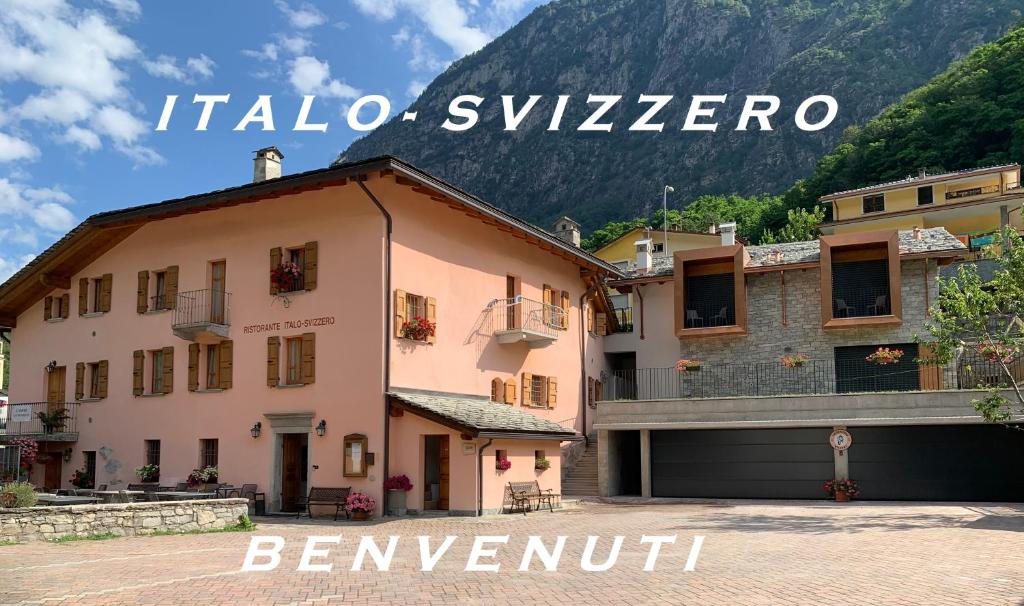 un bâtiment en face d'une montagne avec les mots italo switzerland dans l'établissement Italo-Svizzero, à Chiavenna