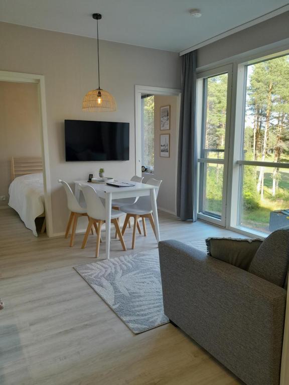 a living room with a couch and a table with chairs at Asunto Kalajoen Golfpuistossa in Kalajoki