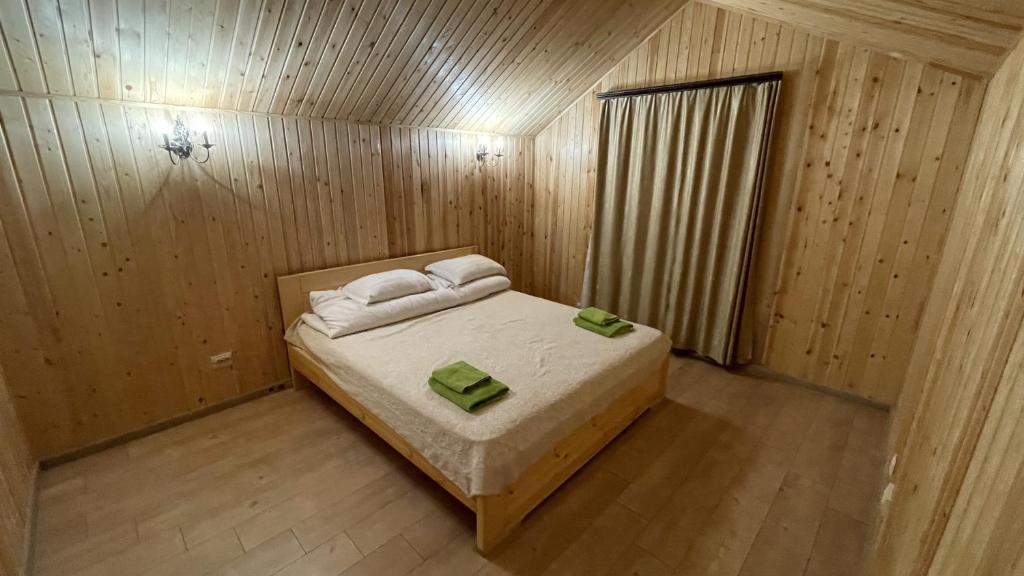 a small bedroom with a bed in a wooden room at Orman Ski in Shchuchinskiy