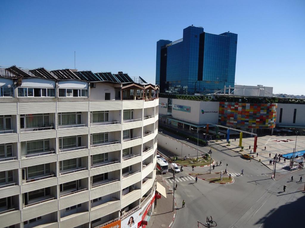 un edificio alto con un estacionamiento delante de él en Bilgehan Hotel, en Antalya