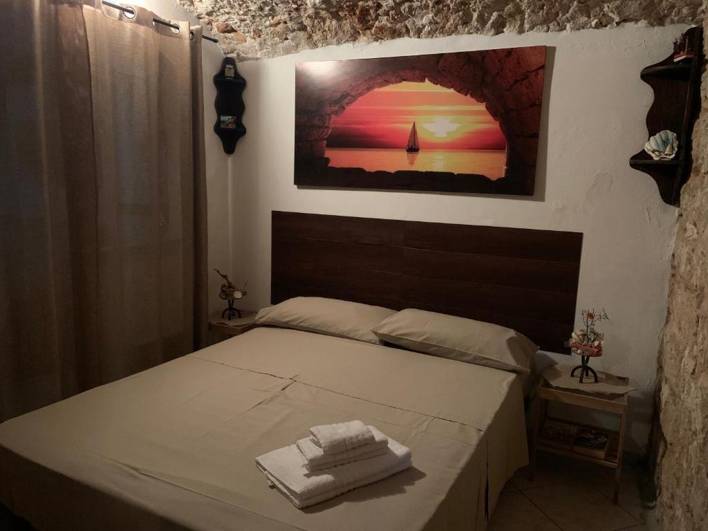 a bedroom with a bed with two towels on it at Casa Ciccio in Isola delle Femmine