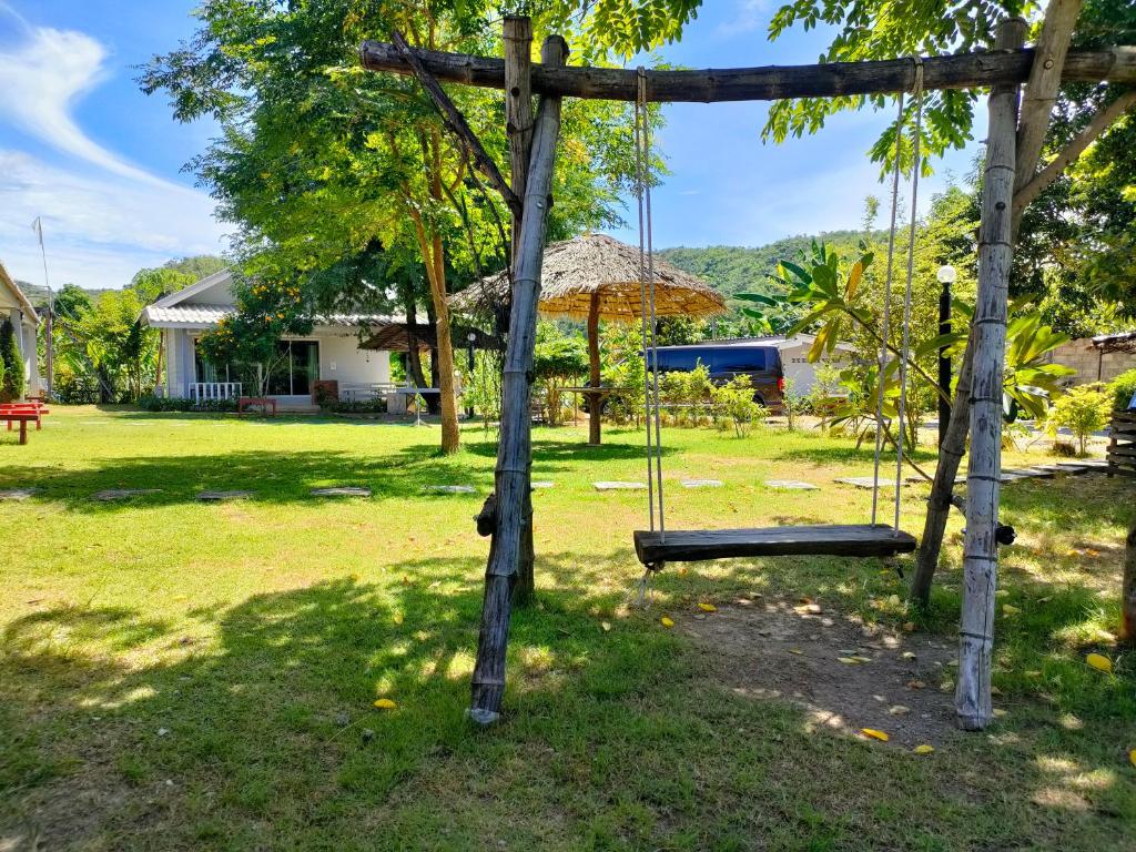 a swing set in the yard of a house at บ้านไม้หอมบูติค สวนผึ้ง in Ban Bo Wi