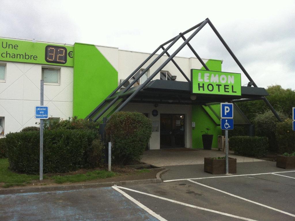 un bâtiment vert avec un panneau indiquant un hôtel dans l'établissement Lemon Hotel - Tourcoing, à Tourcoing