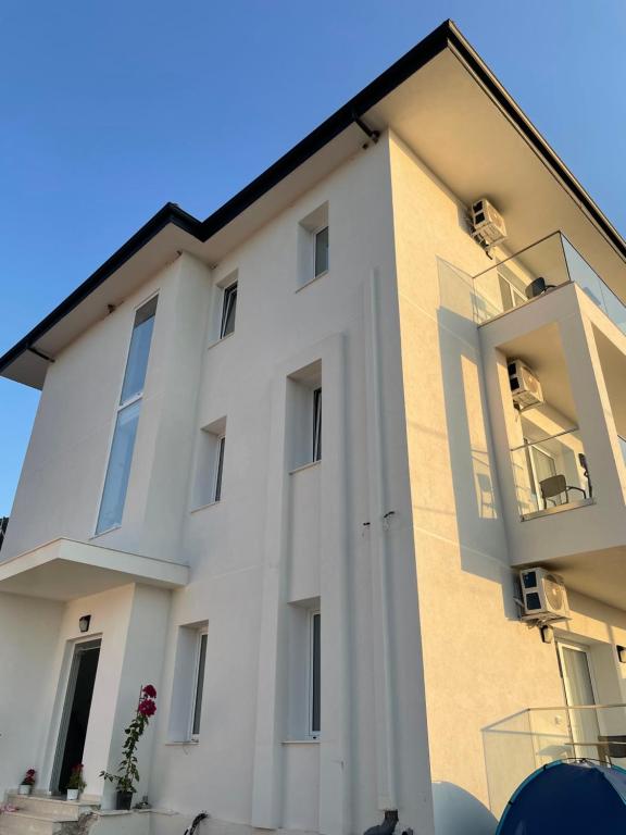 a white building with windows and a blue sky at SEA & LAKE VIEW VILLA in (( Kalive Gjoka ))