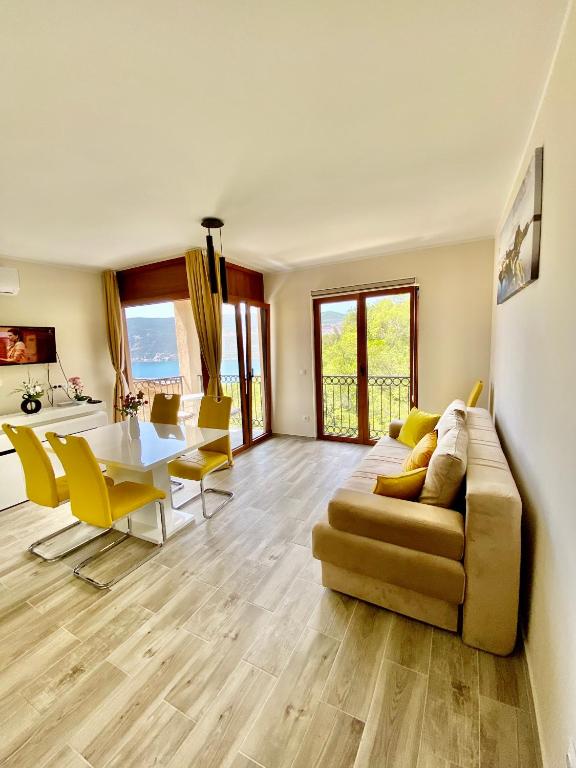a living room with a couch and a table and chairs at Adria Sea & Mountains in Herceg-Novi