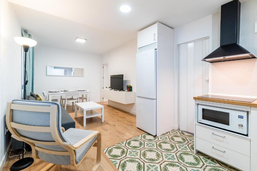 a kitchen with a white refrigerator and a chair at Modern Plaza de Toros Apartment with Free Parking in Granada