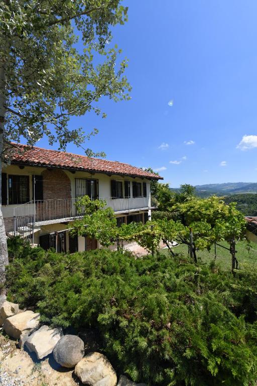 a house on a hill with trees and bushes at Cascina Flino - Tra le vigne - Appartamento 2 in Alba