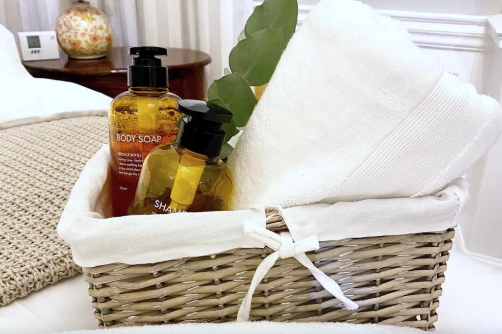 a basket with two bottles of essential oils on a bed at Exclusive Georgian apartment in centre of Bath in Bath