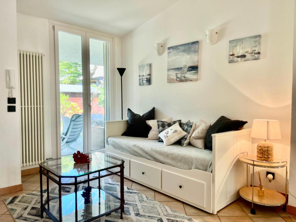 - un salon avec un canapé et une table en verre dans l'établissement Villa Seashell, à Lignano Sabbiadoro