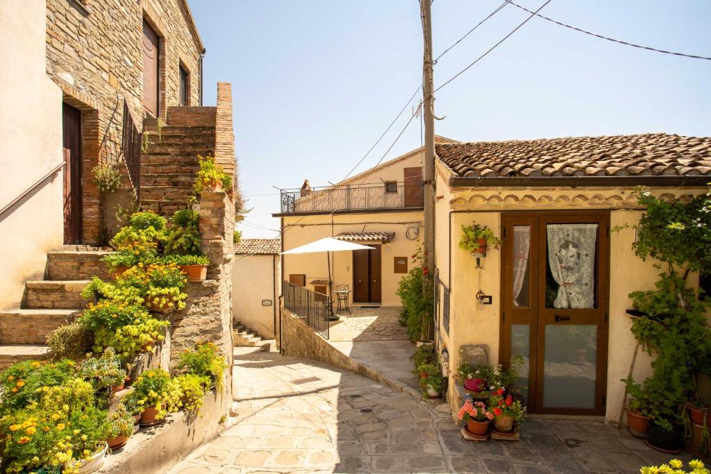 une allée avec des plantes en pot et un bâtiment dans l'établissement Il Paesaggio Lunare, à Aliano