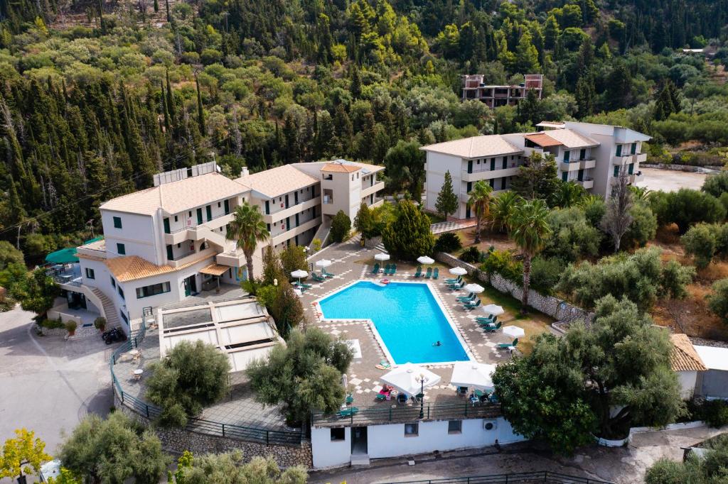 a large building with a pool and trees at Santa Marina Hotel in Agios Nikitas