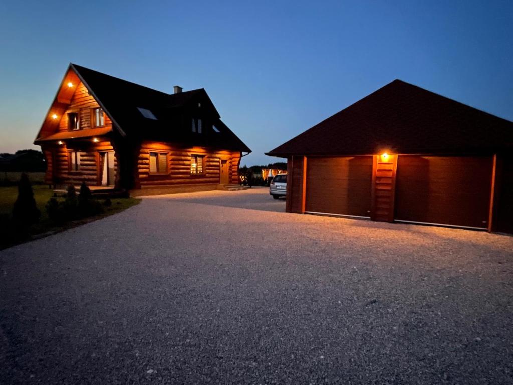 a couple of wooden houses with a garage at Chata z Bala in Babiak