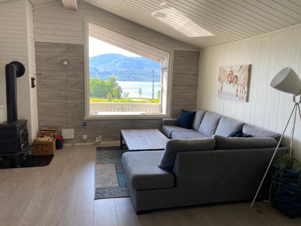 a living room with a couch and a large window at Nissedal- en liten perle ved Nisser 