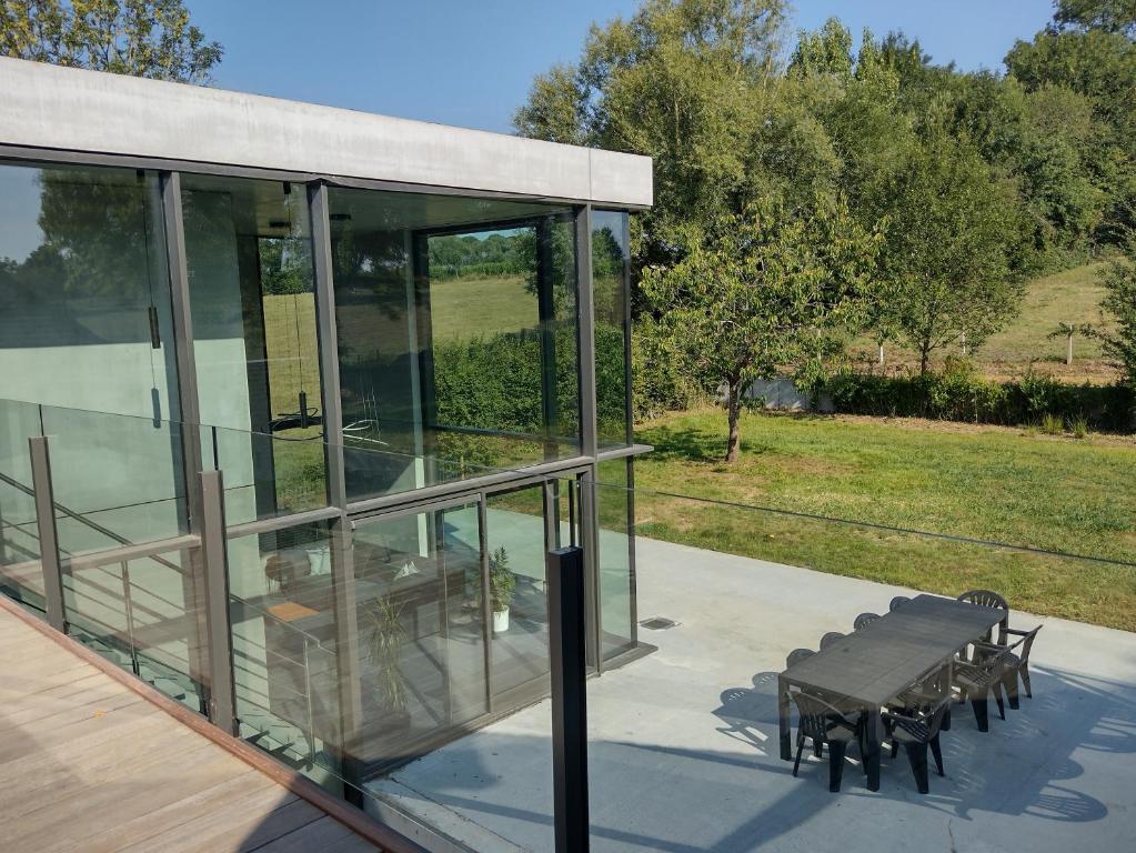 a glass building with a picnic table and benches at The Kettle House - Manor in Sint-Pieters-Leeuw