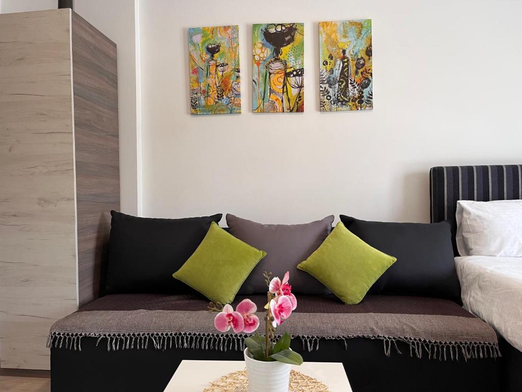 a living room with a couch and three paintings on the wall at Milmari P74, Quest apartmani, Kopaonik in Kopaonik