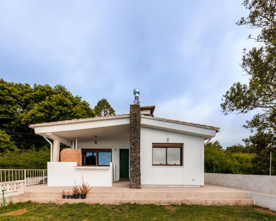 una casa blanca con chimenea de ladrillo en Maison Mialon: country house amidst of nature en La Esperanza