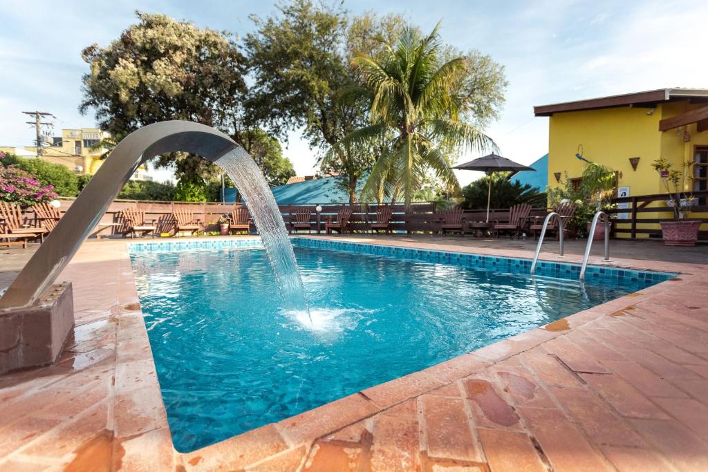 una piscina con una fuente de agua en un patio en Pousada Céu de Estrelas, en Bonito