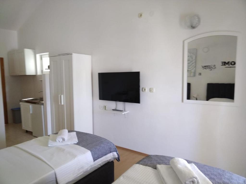 Habitación con 2 camas y TV en la pared. en Apartments Tony - near the sea, en Stomorska