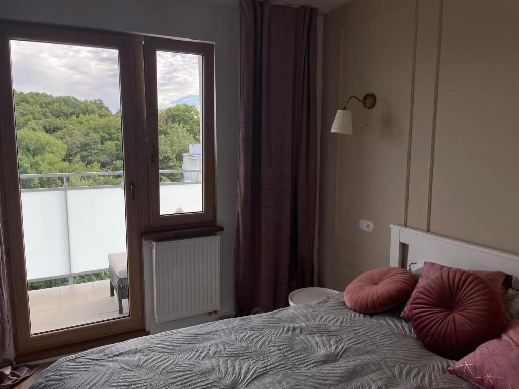 a bedroom with a bed with a large window at cosy condo 5 min do plaży z balkonem Gdynia in Gdynia