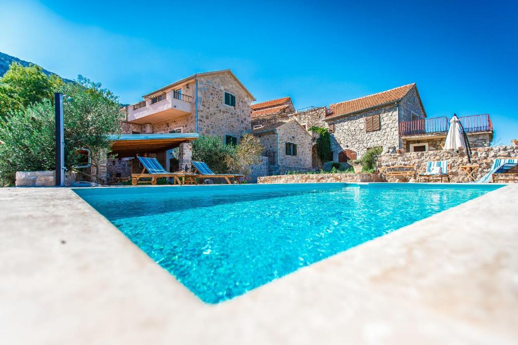 a villa with a swimming pool and a house at Villa Natura in Pitve