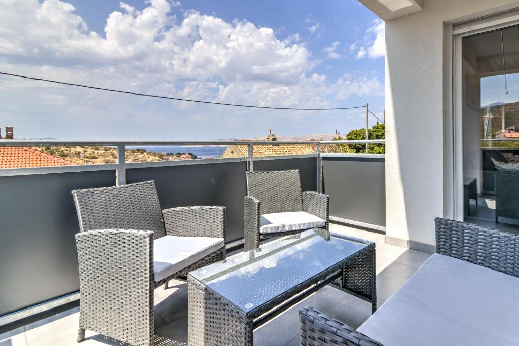 a balcony with chairs and a table with a view at Damar Apartmani in Senj