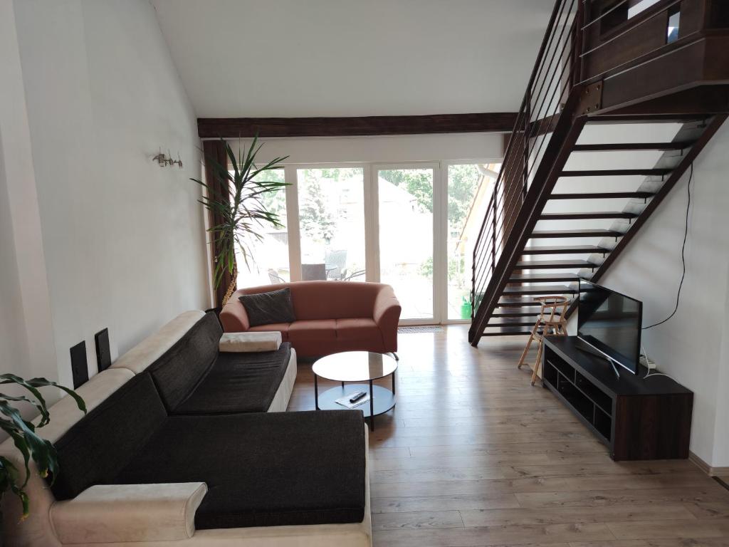 uma sala de estar com um sofá e uma mesa em Attic Apartment em Piešťany