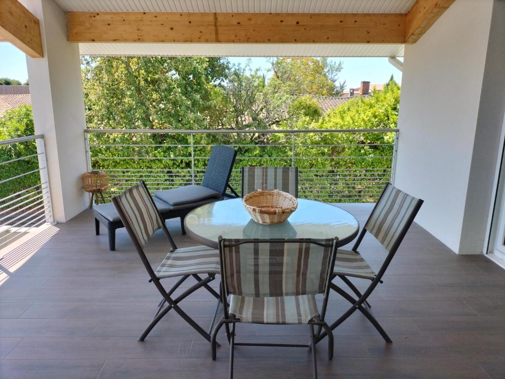 patio ze stołem i krzesłami na balkonie w obiekcie COSY LODGE GITE APPARTEMENT MEUBLE CiTY BREAK w Tuluzie