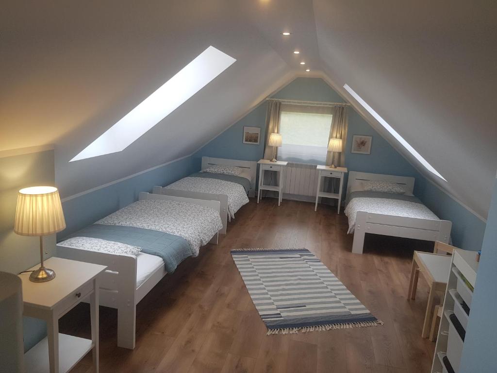 a attic room with four beds and a window at Apartamenty Tylicki Poranek in Tylicz