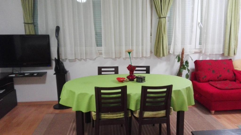 a living room with a green table and a red couch at STUDIO APARTMAN Marita in Split