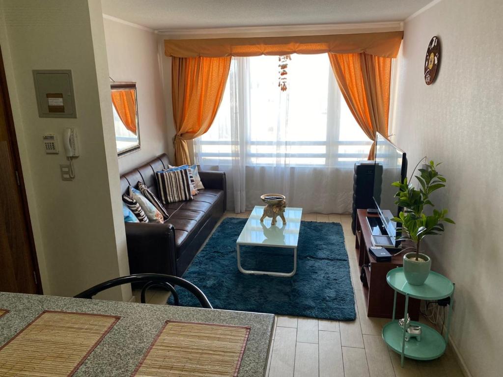 uma sala de estar com um sofá e uma mesa em departamento Amoblado Paola 1 em Calama