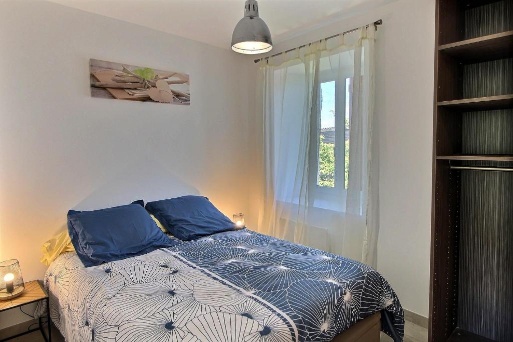 um quarto com uma cama com almofadas azuis e uma janela em Apt type 3 en Duplex sur EVIAN les Bains vue lac em Évian-les-Bains