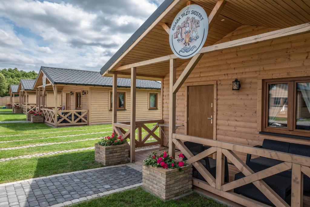 a cabin with a sign on the side of it at Osada Trzy Siostry in Pobierowo