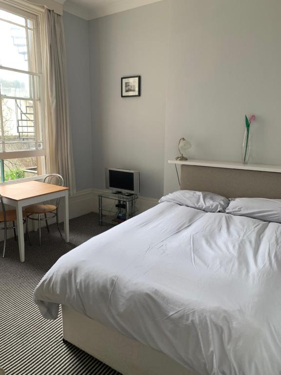 a bedroom with a bed and a desk and a window at Studio flat Brighton Hove border in Brighton & Hove