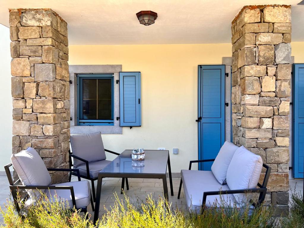 un patio con sillas, una mesa y puertas azules en Casa Histria Apartments en Šmarje