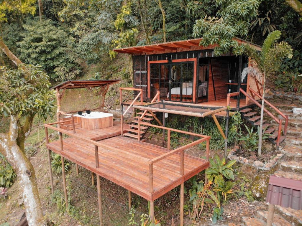 a small house with a deck in the woods at Waira Eco Lodge in Villavicencio