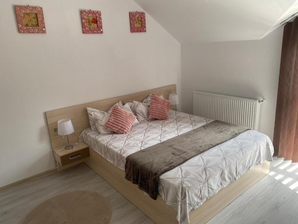 a bedroom with a bed with two pillows on it at Rebeca Apartament in Lugoj
