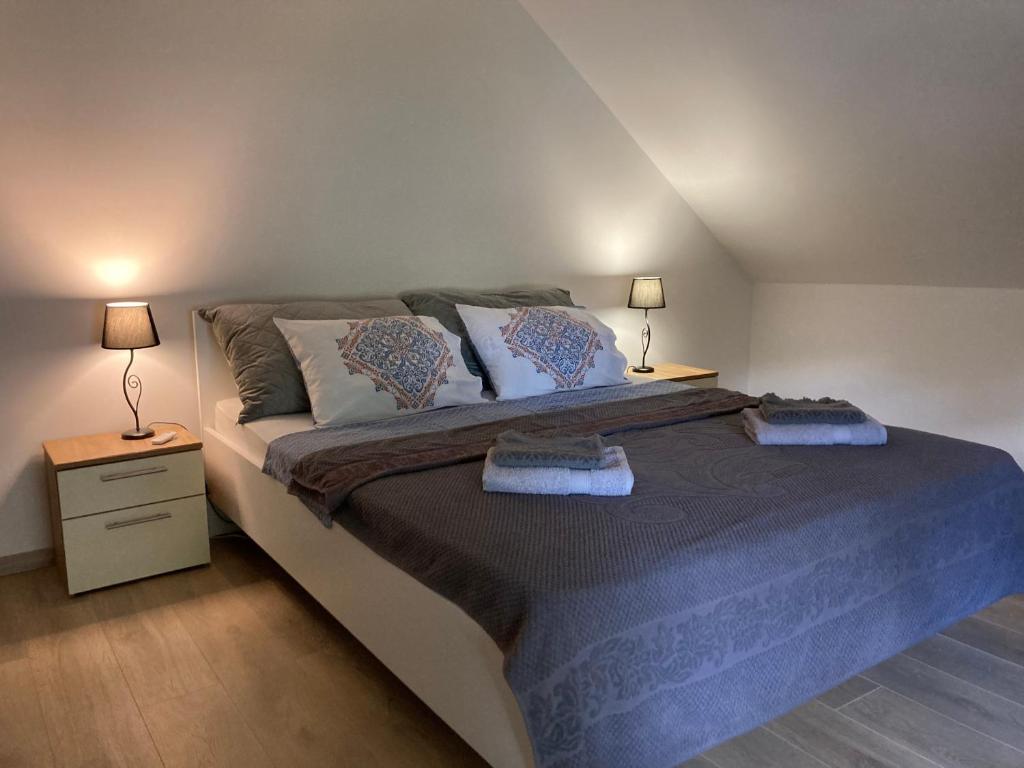 een slaapkamer met een groot bed met 2 lampen bij Enjoy Gardos apartment in Belgrado
