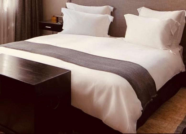 duże łóżko z białą pościelą i poduszkami w obiekcie La Guta Studio Suite The Campari Suite w Jerozolimie