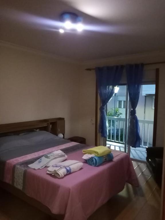 um quarto com uma cama com lençóis roxos e uma janela em Bragança Home For Working, Tourists, Erasmus Students, Digital Nomads em Brangança