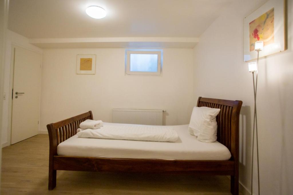 a bed with white sheets and pillows in a room at Business Apartment in Kaiserslautern