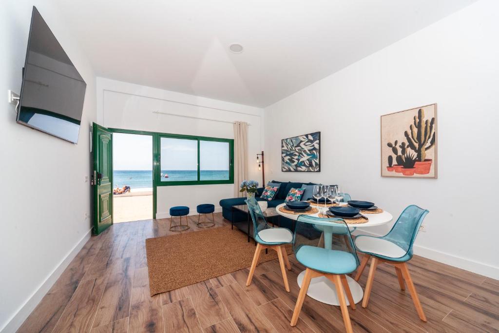 een woonkamer met een tafel en stoelen en de oceaan bij Luxury Suite Sea Front V in Playa Honda