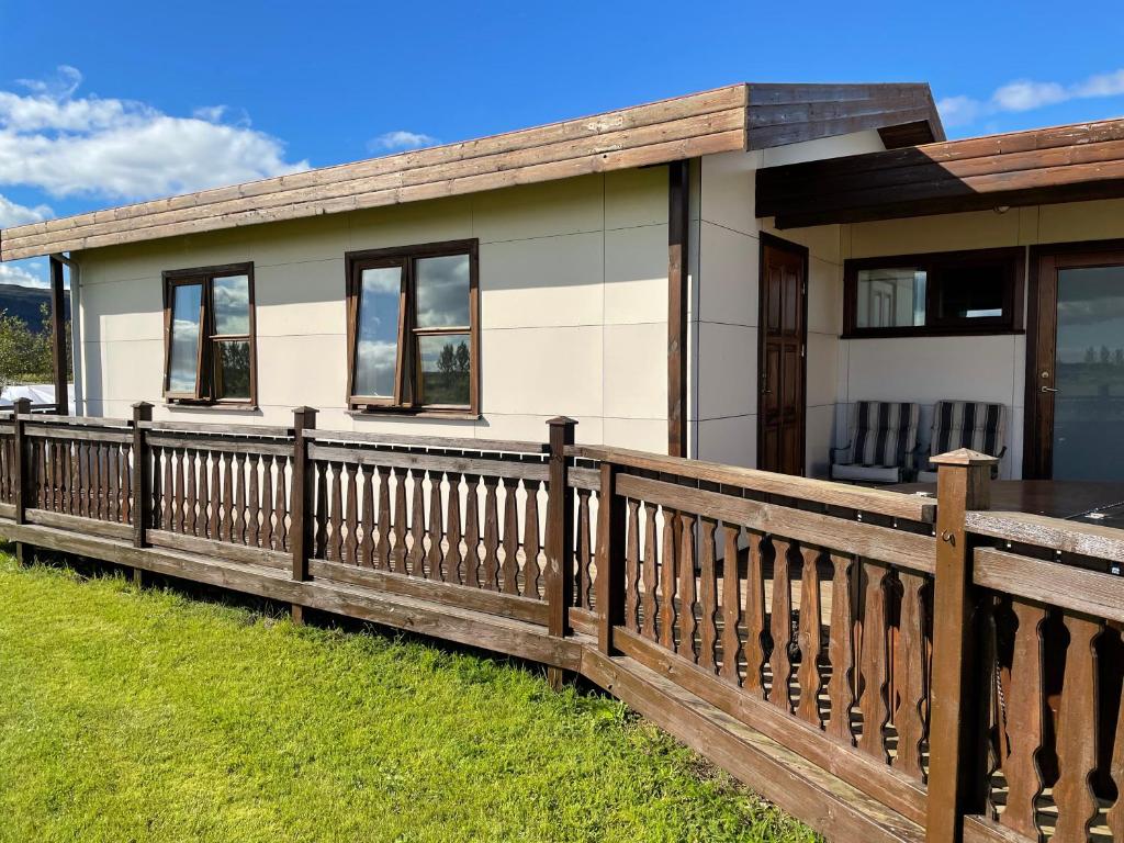 a house with a wooden fence in front of it at Halakot guesthouse in Laugardælir