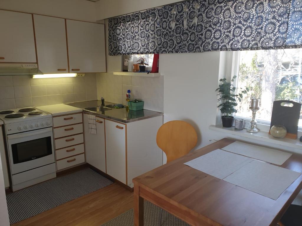 a kitchen with a table and a stove and a window at Studio Chip in Taalintehdas