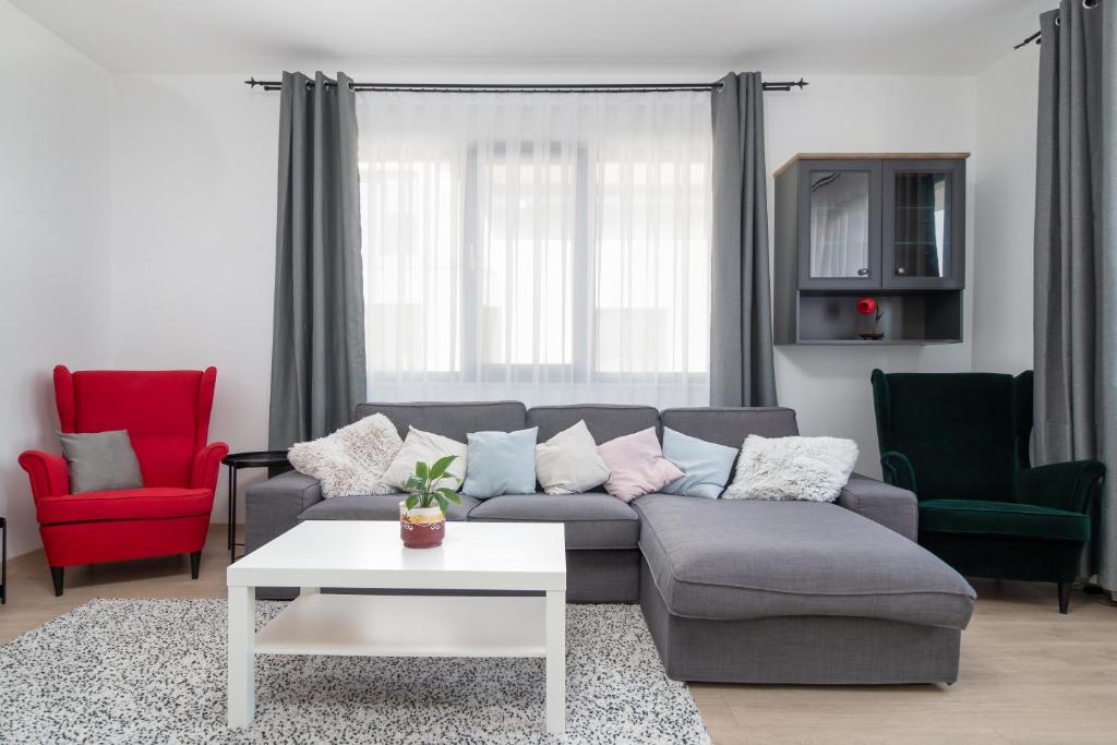 ein Wohnzimmer mit einem Sofa und 2 Stühlen in der Unterkunft Zola Guest House in Oradea