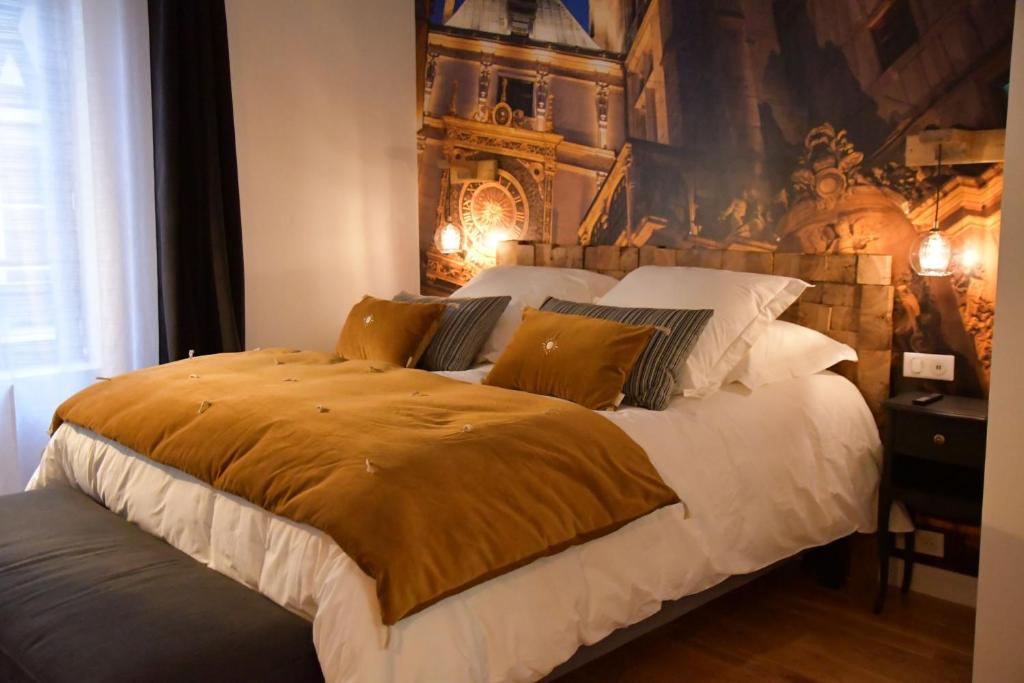 Un dormitorio con una cama grande con una manta amarilla. en L'escale du Gros Horloge en Ruan