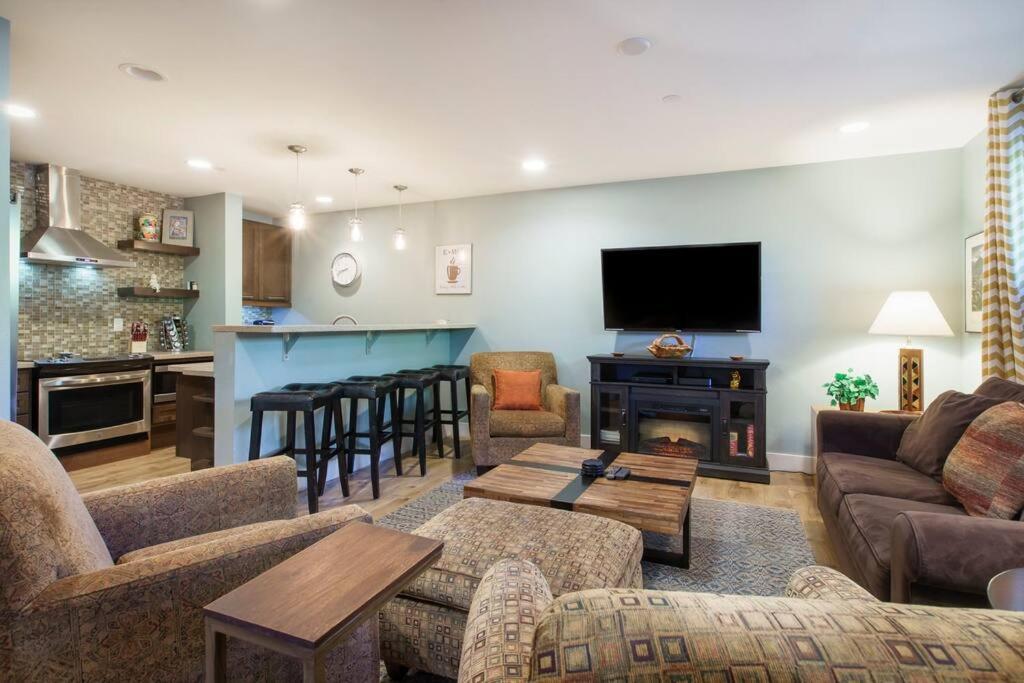 a living room with couches and a tv and a kitchen at Fresh and Airy Condo in downtown Breck! in Breckenridge