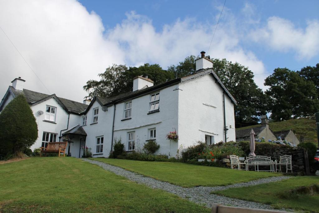 une maison blanche avec une pelouse devant elle dans l'établissement Belle Green Bed and Breakfast, à Sawrey