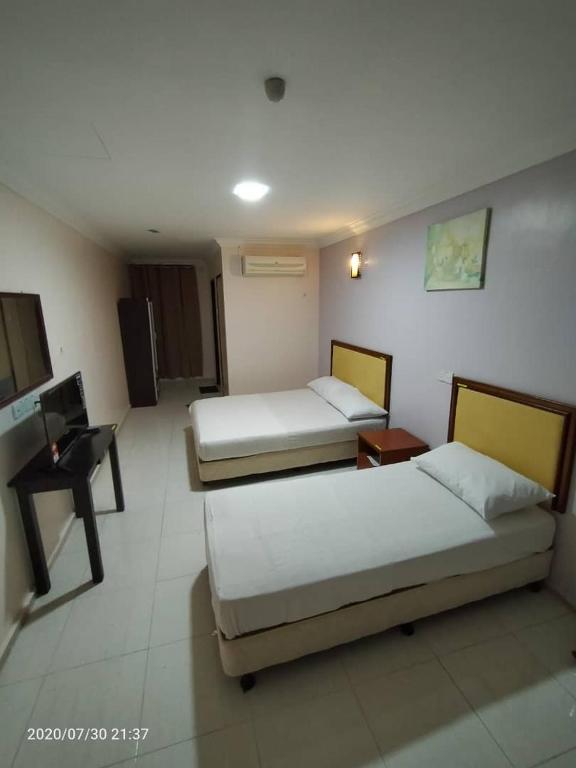 Postel nebo postele na pokoji v ubytování TAMIM SUITE GROUP HOTEL Dungun