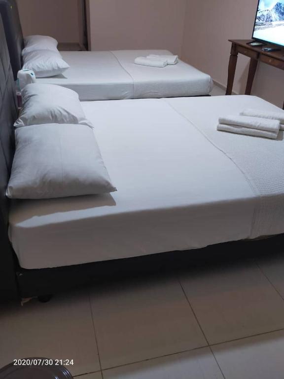 Postel nebo postele na pokoji v ubytování TAMIM SUITE GROUP HOTEL Dungun